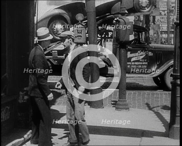 Male Civilian Stopping People On the Street Perhaps Begging or Perhaps Asking For a Job, 1932. Creator: British Pathe Ltd.
