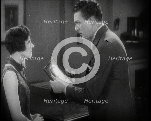 Carl Brisson and Lilian Hall-Davis Acting in a Scene. Carl Brisson is Holding a Framed..., 1920s. Creator: British Pathe Ltd.
