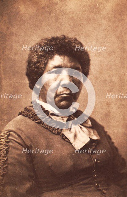 Studio portrait of unidentified woman dressed in a rouched jacket and large striped..., c1870-c1879. Creator: Unknown.