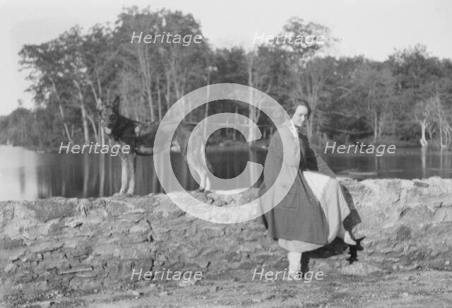 Mower, Margaret, Miss, with dog, seated outdoors, not before 1916. Creator: Arnold Genthe.