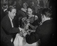 British Men and Women Sitting and Talking and Smoking at a Table in a Nightclub, 1922. Creator: British Pathe Ltd.