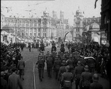 German Soldiers Marching Down a Street as a Crowd Watches, 1930s. Creator: British Pathe Ltd.