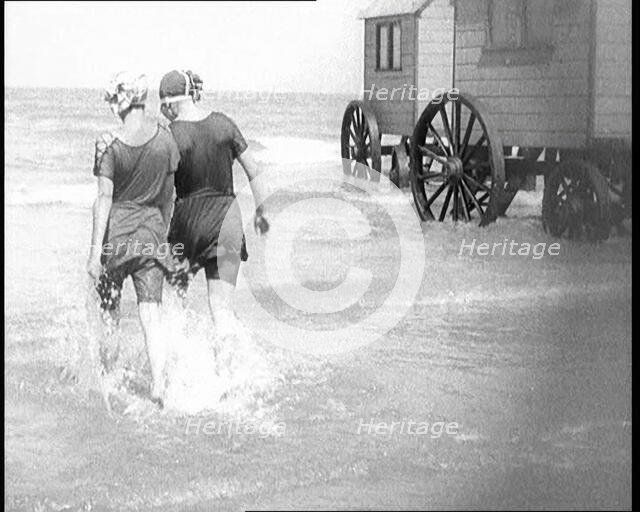 Two Female Civilians in Bathing Suits Walking Through Shallow Water Away from the Camera..., 1924. Creator: British Pathe Ltd.