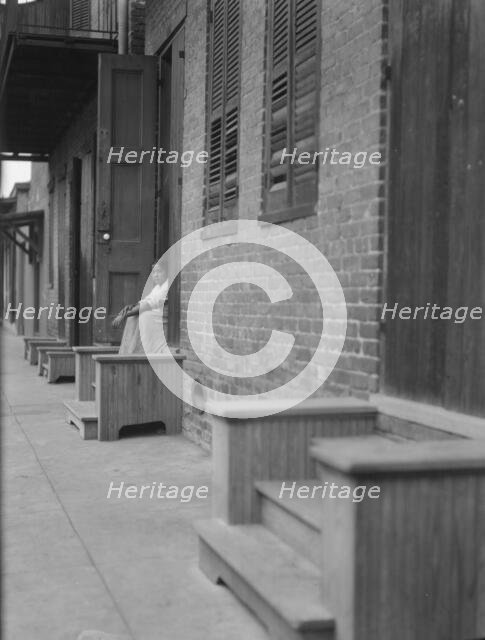 Woman sitting on steps, New Orleans or Charleston, South Carolina, between 1920 and 1926. Creator: Arnold Genthe.