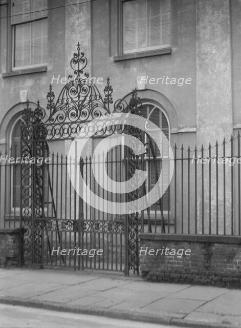 Unidentified building behind a fence, New Orleans or Charleston, South Carolina, c1920-1926. Creator: Arnold Genthe.