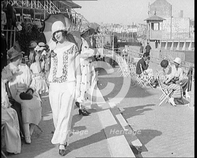Female Civilian Wearing Smart outfit and Hat Holding a Parasol Walking Towards the Camera..., 1920. Creator: British Pathe Ltd.