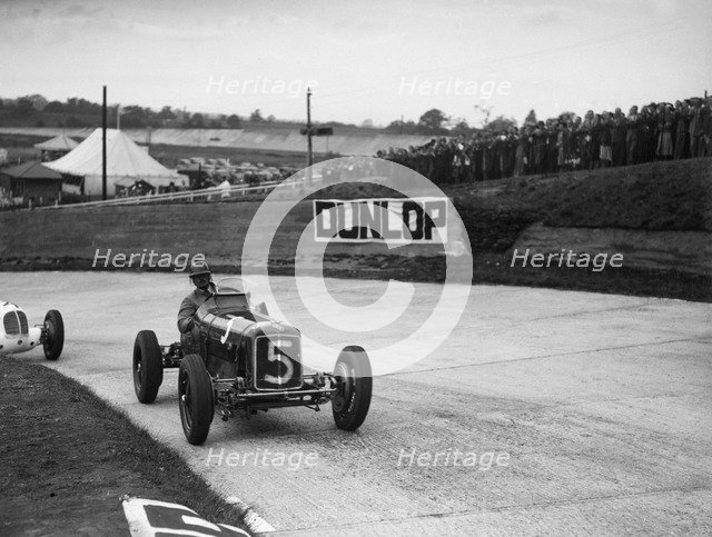 ERA and Maserati taking a corner in a race at Brooklands. Artist: Bill Brunell.