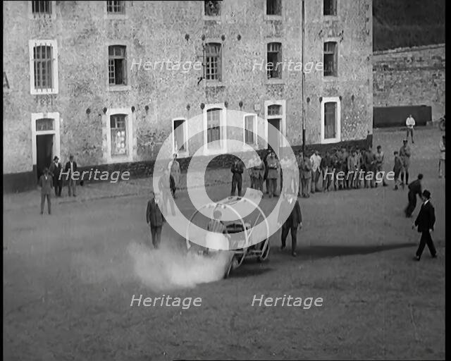 A Crashable Car With a Circular Frame Allowing It To Roll Over Being Tested in Front of..., 1926. Creator: British Pathe Ltd.