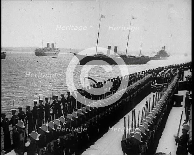 British Sailors Standing to Attention as British Warships Sail Past, 1935. Creator: British Pathe Ltd.