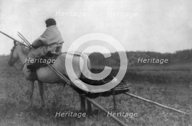 Atsina Indian on horse pulling travois, c1908. Creator: Edward Sheriff Curtis.
