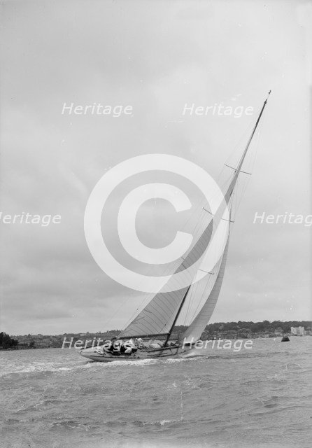 12 Metre class sailing yacht heeling over in windy conditions on upwind leg, 1938. Creator: Kirk & Sons of Cowes.