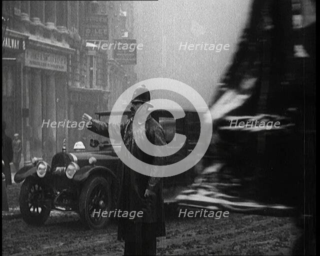 A Male Police Officer Directing the Traffic in the Snow, Facing the Camera, 1920s. Creator: British Pathe Ltd.
