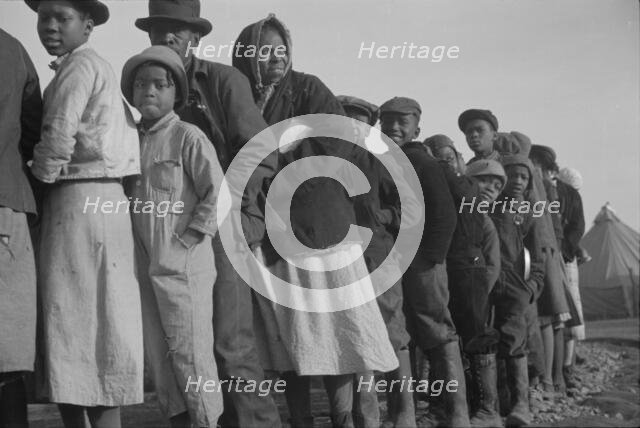 Possibly: Negroes in the lineup for food at the flood refugee camp, Forrest City, Arkansas, 1937. Creator: Walker Evans.