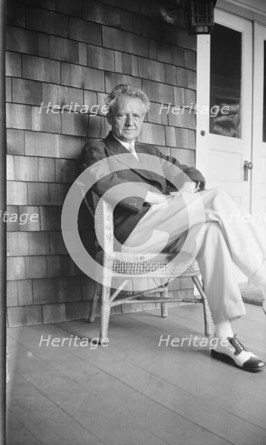 Arnold Genthe seated in a chair on a porch, between 1911 and 1942. Creator: Arnold Genthe.