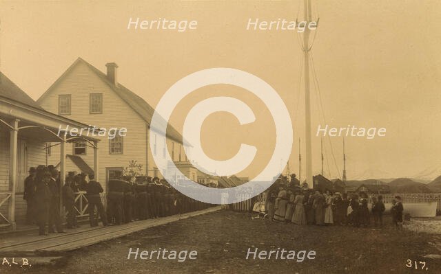 Sailors standing in line on boardwalk with a group of local women and men standing..., 1894 or 1895. Creator: Alfred Lee Broadbent.