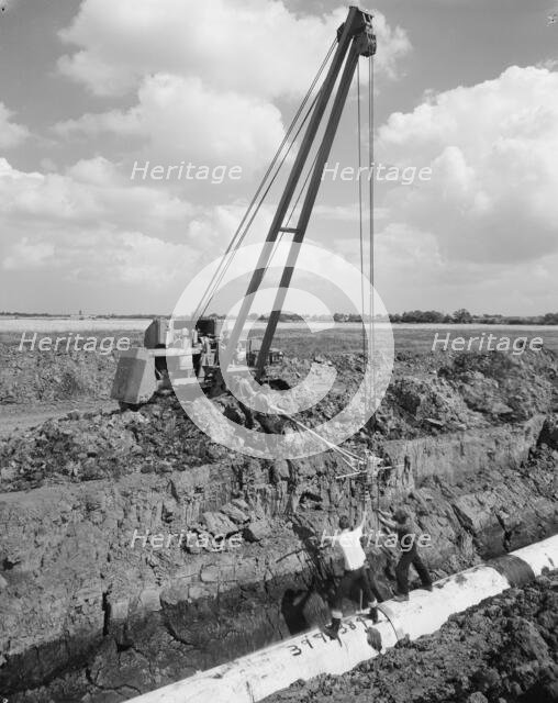 Workers laying a section of the Fens gas pipeline, Norfolk, 10/08/1967. Creator: John Laing plc.