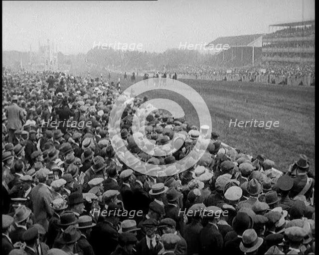 A Crowd of People Watching Horses Racing at Ascot Race Track, 1924. Creator: British Pathe Ltd.