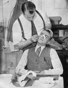 England captain Eddie Hapgood receives treatment for a broken nose after a match with Italy, 1934.Artist: Topical Press Agency