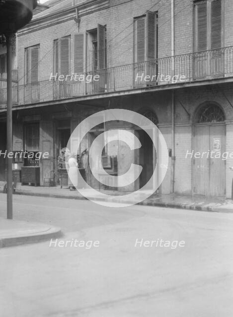 People standing by the doorway of a furniture shop in the French Quarter, New Orleans, c1920-1926. Creator: Arnold Genthe.