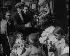 A Group of Civilian Children Dancing in Front of a Hurdy Gurdy Watched by a Small Crowd..., 1920. Creator: British Pathe Ltd.