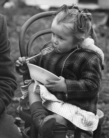 Gypsy girl eating, 1960s.