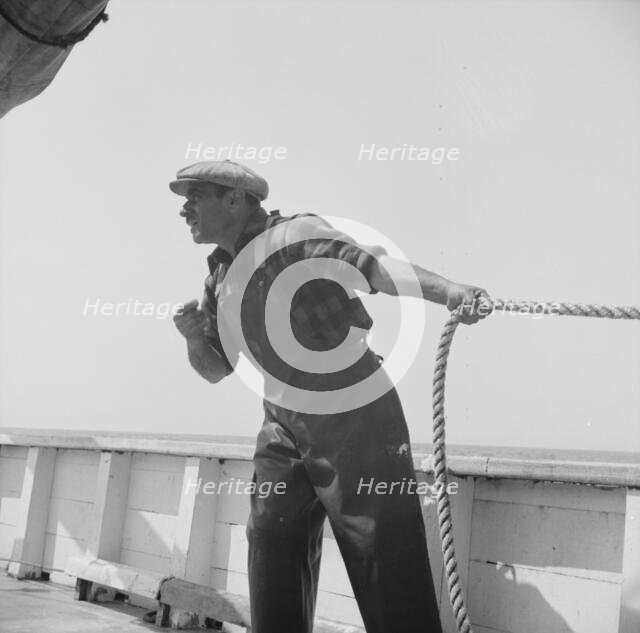 Vito Camella hollers for help to anchor a dory, Glocester, Massachusetts, 1943. Creator: Gordon Parks.