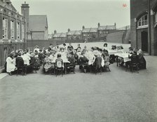 Children eating dinner at tables in the playground, Shrewsbury House Open Air School, London, 1908. Artist: Unknown.