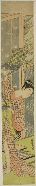 Young Woman Hanging a Painting, c. 1771. Creator: Isoda Koryusai.