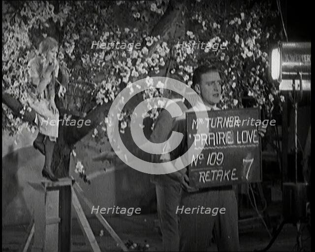 Female Actor Sitting in a Blossom Tree Whilst a Male Civilian Talks to Her..., 1920s. Creator: British Pathe Ltd.
