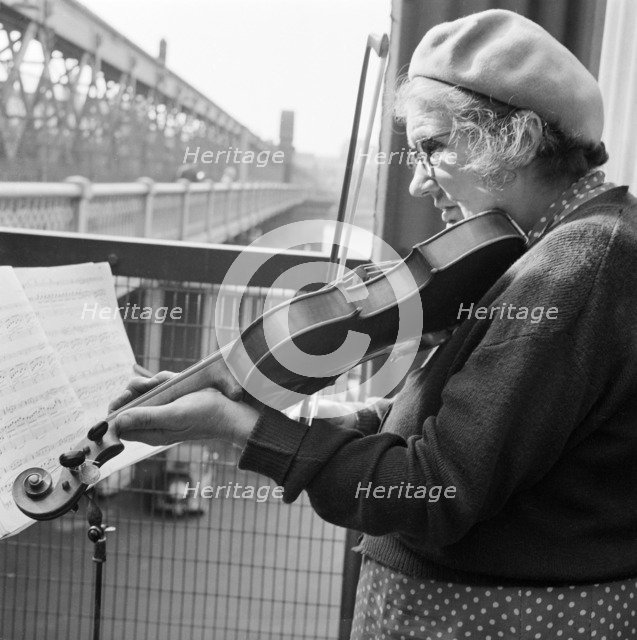 Woman busker playing the violin, Hungerford Bridge, London, 1946-1959. Artist: John Gay