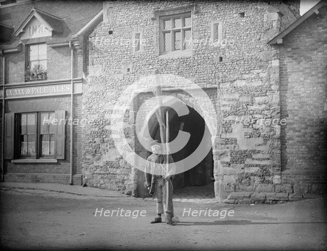 A shrimper with his equipment standing in front of Old Fishers Gate, Sandwich, Kent, c1860-c1922. Artist: Henry Taunt
