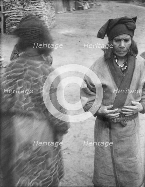 Two Ainu women in the village lane, 1908. Creator: Arnold Genthe.