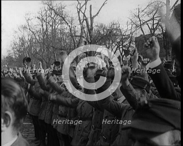 Group of Male Civilians Standing and Cheering With Their Fists Raised in the Air, 1924. Creator: British Pathe Ltd.