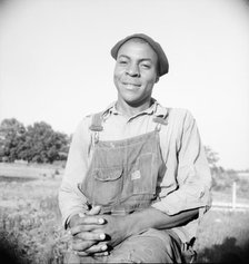 Plough boy sitting on fence after a day's work, Eutaw, Alabama, 1936. Creator: Dorothea Lange.