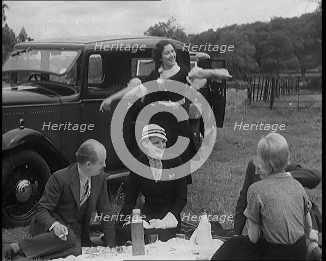 Male and Female Civilians Having a Picnic Beside a Car, 1931. Creator: British Pathe Ltd.