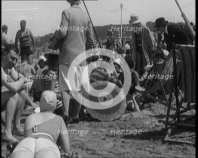Civilians Wearing Swimsuits Leasuring on a Beach, 1920. Creator: British Pathe Ltd.