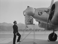 Plant quarantine inspectors examining plane at the Glendale Airport, California, 1937. Creator: Dorothea Lange.