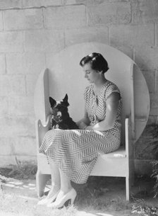 Mrs. Walter Fletcher with dog, seated outdoors, between 1933 and 1942. Creator: Arnold Genthe.