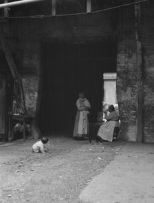 Women and children in a courtyard, New Orleans, between 1920 and 1926. Creator: Arnold Genthe.