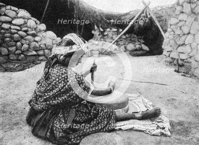 A nomad maid of the mill preparing couscous, Algeria, 1922.Artist: A Bougaut