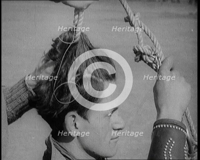 Native American Man Having a Rope Tied Into His Hair, 1921. Creator: British Pathe Ltd.