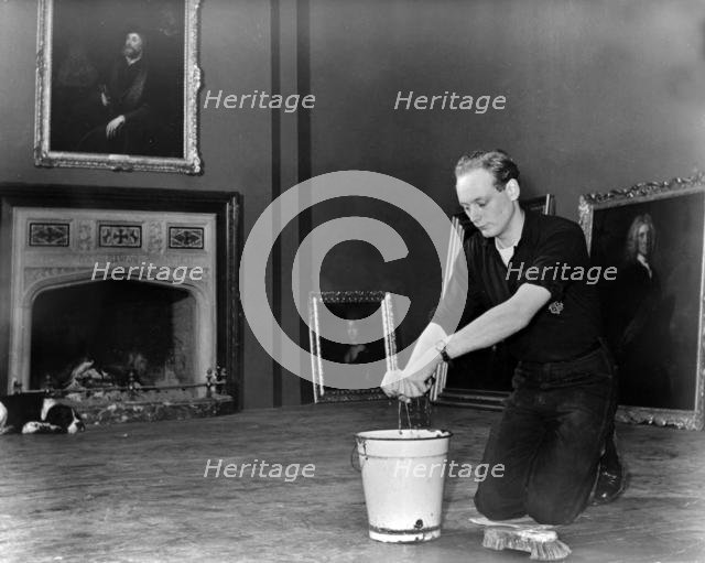 Edward, Lord Montagu of Beaulieu scrubbing floors in Palace House 1952. Creator: Unknown.