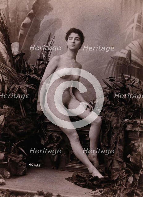 A young woman seated on a low balustrade posing naked, c1900. Creator: Unknown.