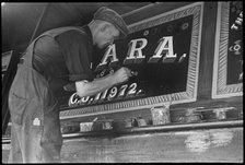 Barge painter Frank Jones, of 3 Edward Street, at work, Leighton Buzzard, Bedfordshire, 1910-60. Creator: George R Long.