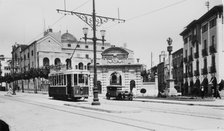 Public tram moving through the streets of Mataró, in front of the Escuelas Pías in a postcard fro…