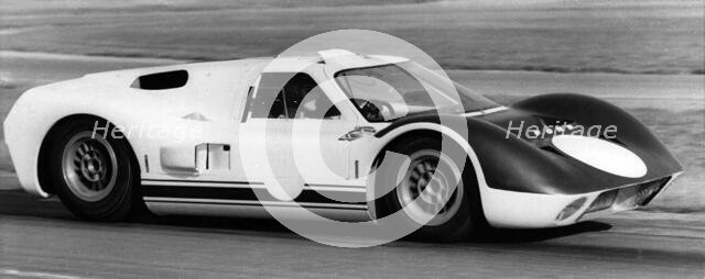 British racing driver and engineer Ken Miles driving a 1966 Ford GT40 J racing car. Creator: Unknown.