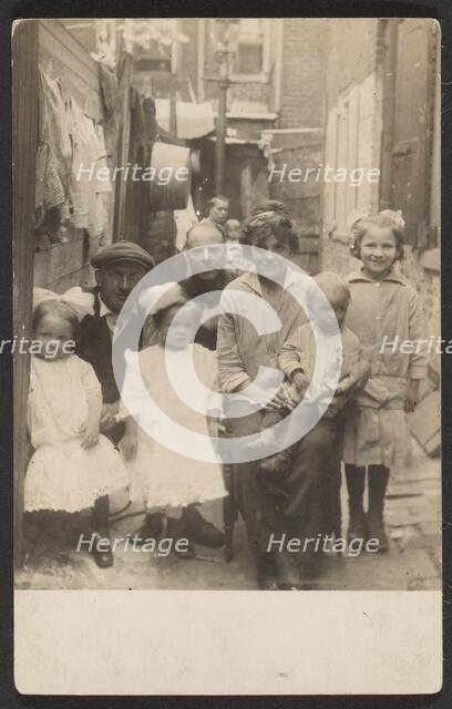 Family portrait in tenement alley, about 1913-1925. Creator: John Frank Keith.
