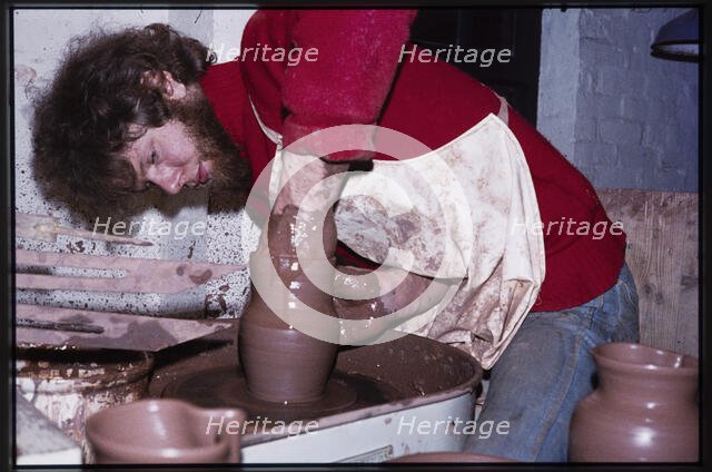 A potter working at a wheel in the Gladstone Pottery Museum, Longton, Stoke-on-Trent, 1975. Creator: Dorothy Chapman.
