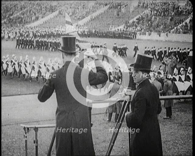 Male Newsreel Camera Operators Carrying Tripods and Equipment, 1920s. Creator: British Pathe Ltd.