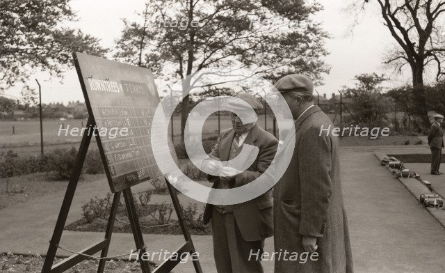 Two men in flat caps look at the bowls scoreboard, York, Yorkshire, 1955. Artist: Unknown